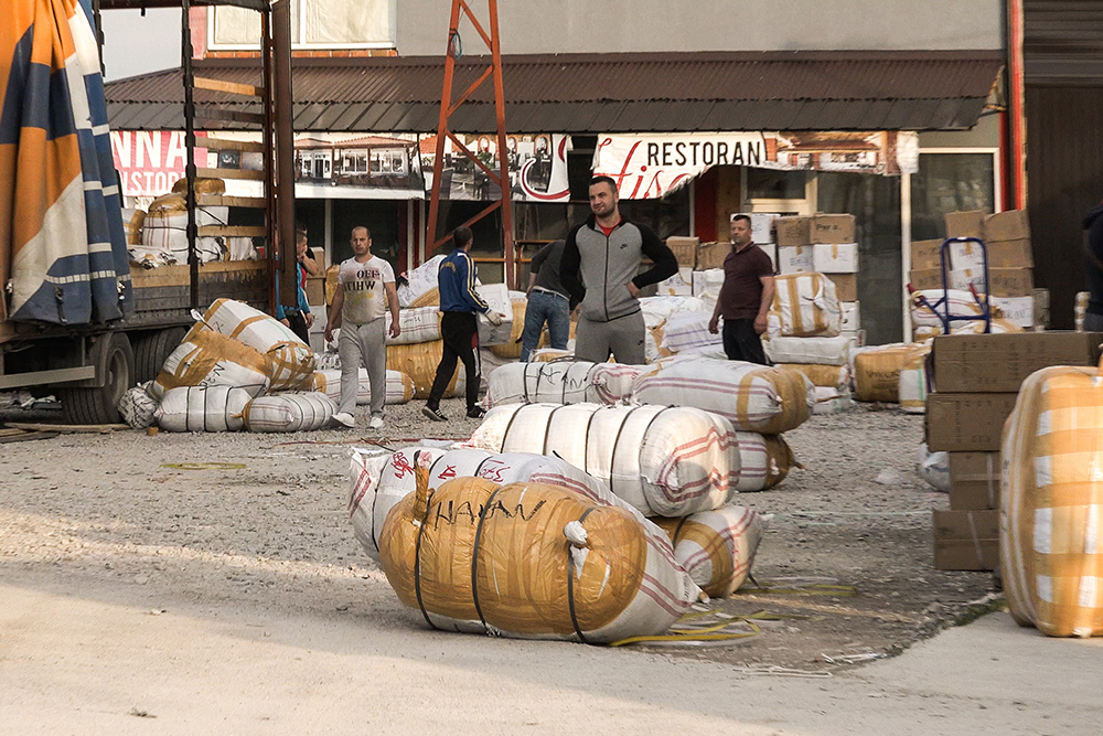 Market workers unload freshly cleared textiles imported by the company “Extrablatt” (Photo: CIN)